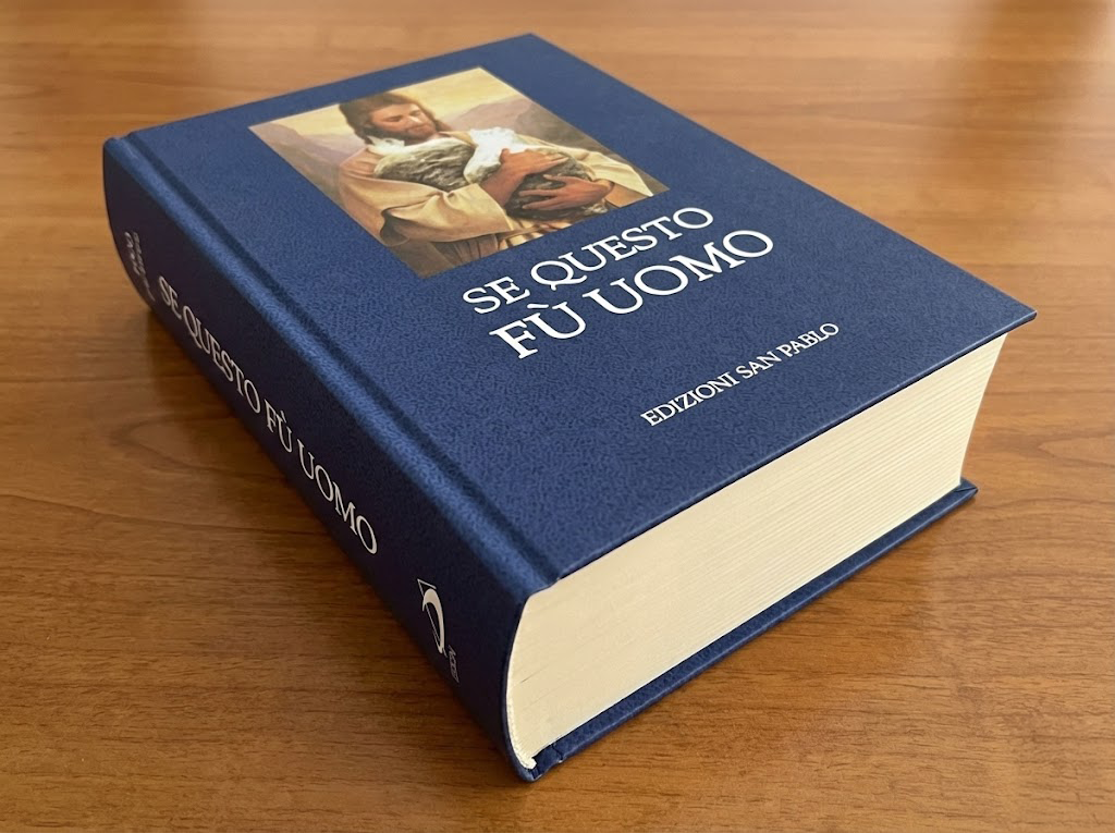 Volume 'SE QUESTO FÙ UOMO', Edizioni San Pablo. Copertina rigida blu con iconografia del Buon Pastore. Pastiche editoriale che mescola sacralità cattolica e nichilismo post-umano.